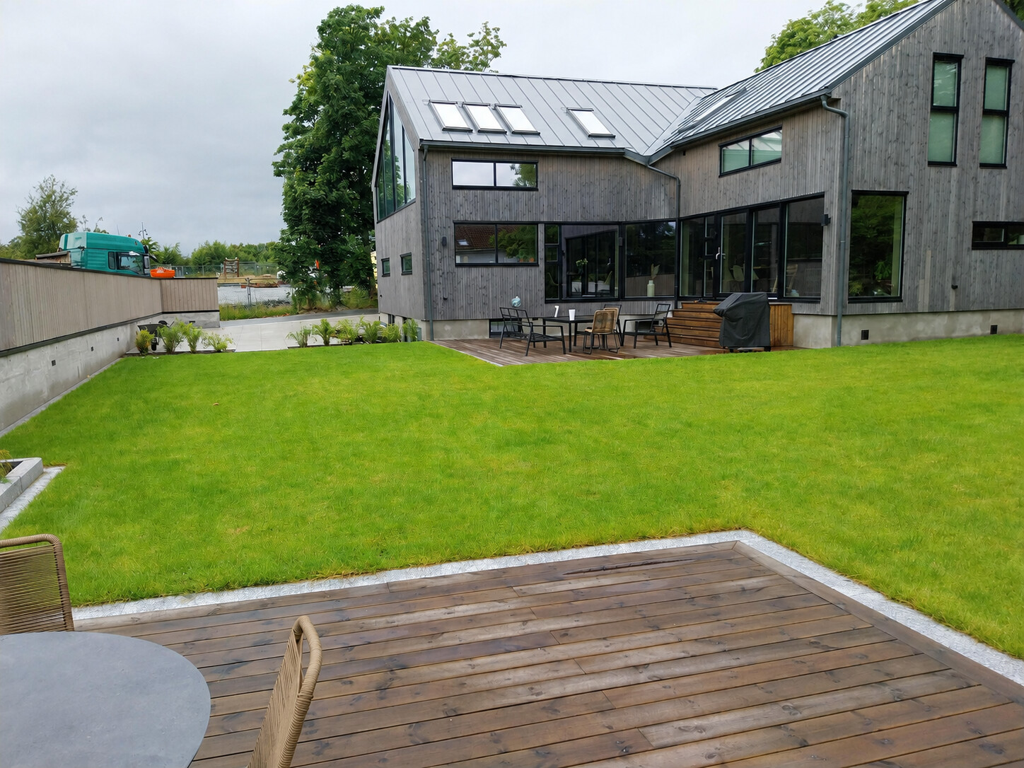 Ferdig hage med ny plen og terrasse i tre langs den moderne boligen